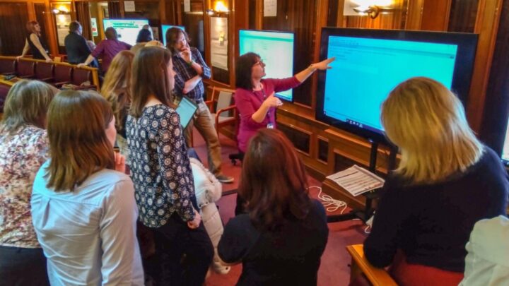 Group of people around a screen viewing a system demo