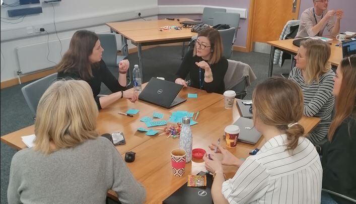 Communications team sat around table discussing newsroom