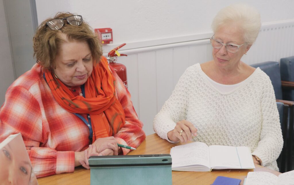 Two people looking at a tablet together