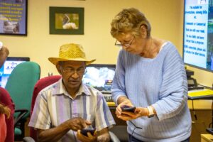 A volunteer helps a learner set up a new smart phone at the Learning Centre in Sturminster Newton