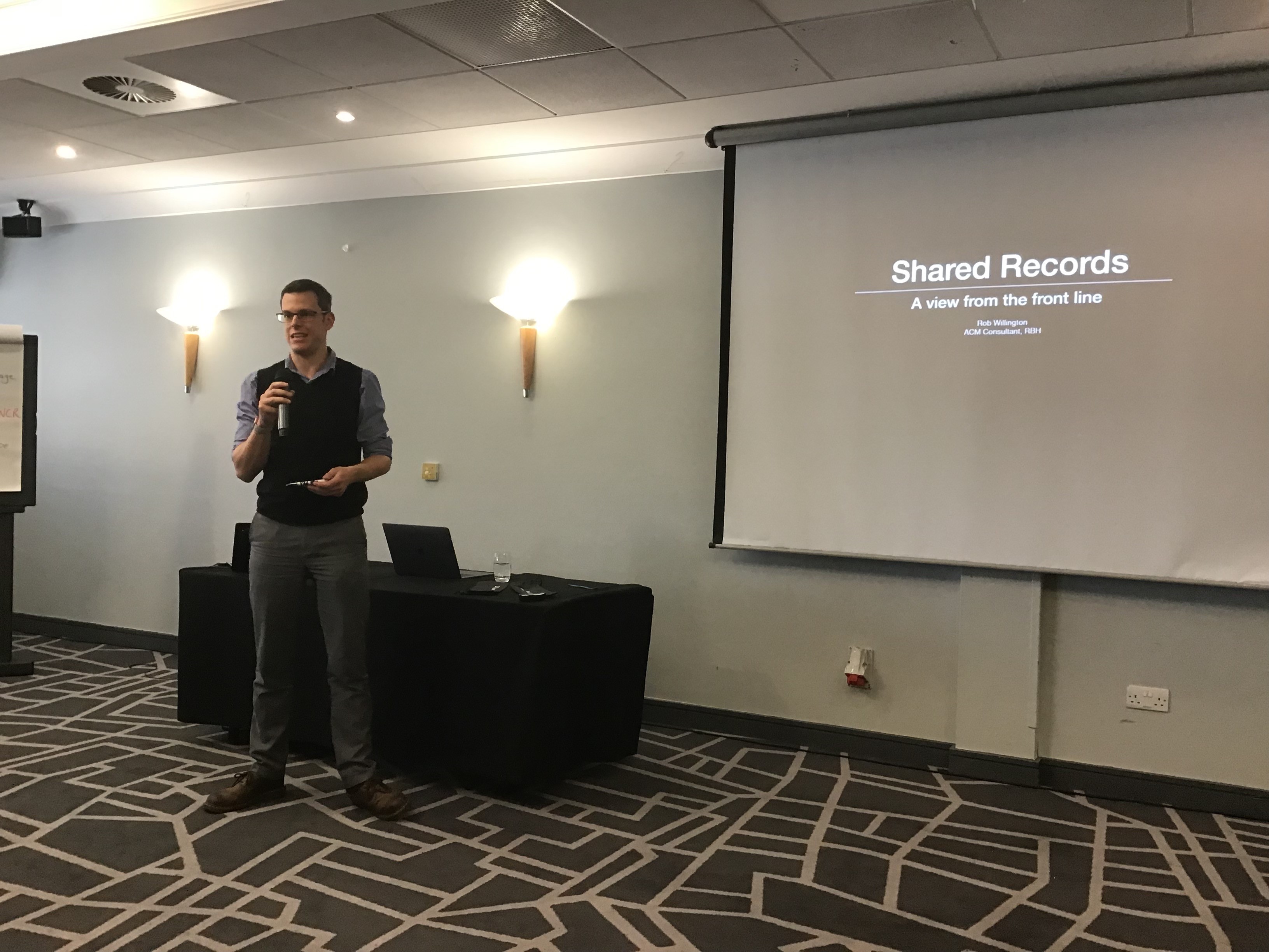 A picture of Dr Rob Willington holding a microphone