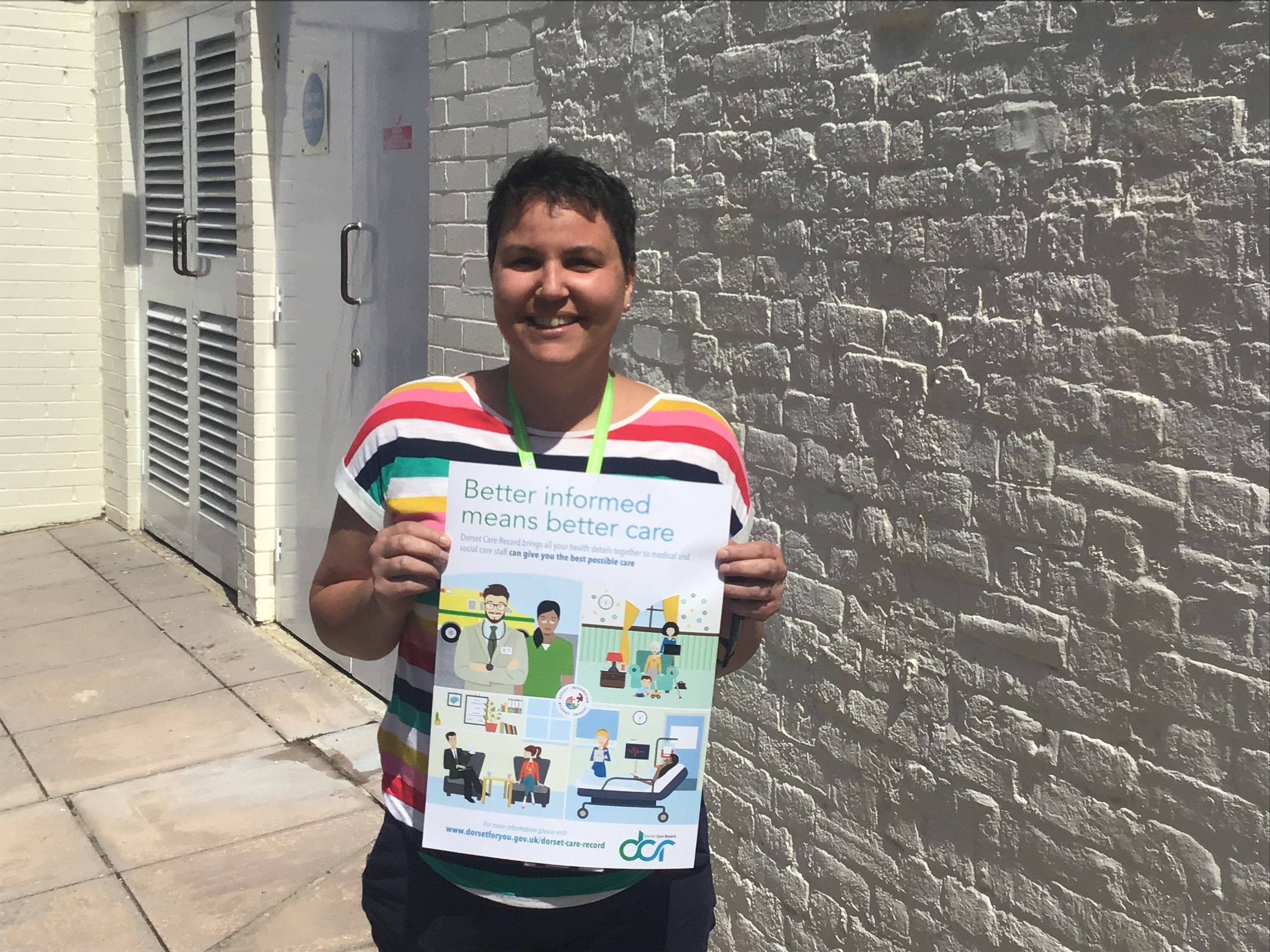 Midwife Chloe holding up a Dorset Care Record poster
