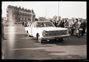Lesley Langley drives along Weymouth Esplanade in a Ford Anglia