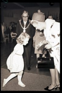 A little girl curtseys to Lesley, with the mayor looking on