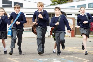 happy children are running across a playground.
