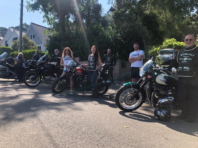 Volunteers working together stood with motor bikes