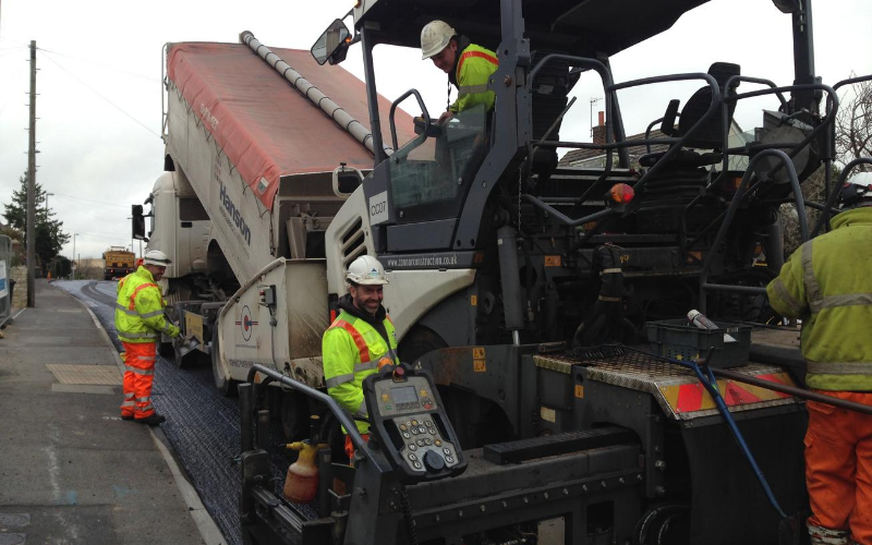 workers on a paving machine