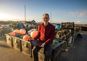Wherever you are in Dorset a Digital Champion is waiting to help you at the other end of the Digital Hotline. Pictured: Digital Champion Andy Penney at Mudeford Quay.