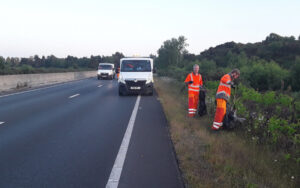 Two men litter picking on verges of A338 into Bournemouth
