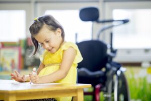 A child is sitting at a table drawing