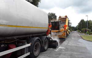 Bitumen tanker and phoenix surface dressing machine applying the treatment on a Dorset road