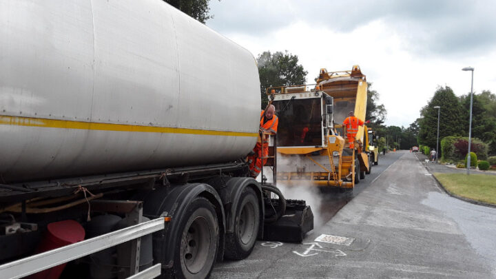 Bitumen tanker and phoenix surface dressing machine applying the treatment on a Dorset road