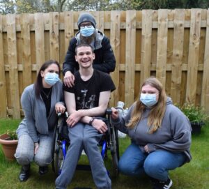 Three women wearing face coverings and a man