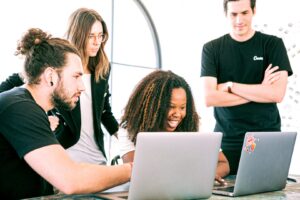 young people in black t shirts looking at computer