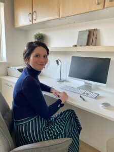 Photo of Hannah Massey, a lawyer for Dorset Council. She is sat at her home desk.