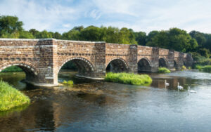 White Mill Bridge over river, swans swimming underneath