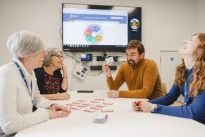 A group of four people talking across a table.