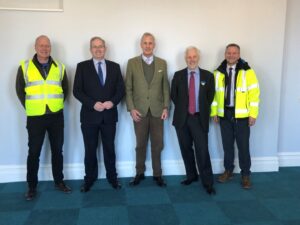 five men, at each end wearing yellow jackets
