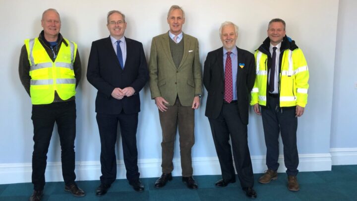 five men, at each end wearing yellow jackets