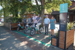 Beryl bikes employees, Dorset Council officers and Councillors at Beryl Bikes bay in Ferndown
