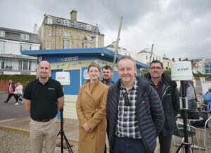 Pic caption – Some of the team behind the Weymouth ‘smart place’ demonstrator. (Left to right) Callum Farrell from Excelerate Group, Sarah Levett from IoTSG, Will Holmes (at the back) Resort Manager for Weymouth and Colin Wood and Tim Robertson from 5G RuralDorset. 