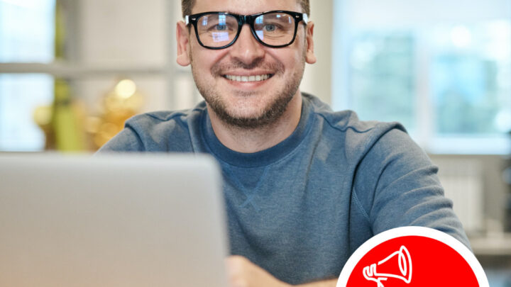 man sat at desk at home with a laptop and carers rights day logo