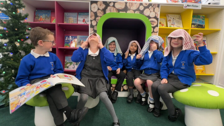 A photo of school children wearing tea towels over their heads, pretending to be shepherds