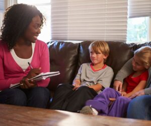 A photo of a social worker talking to two young children