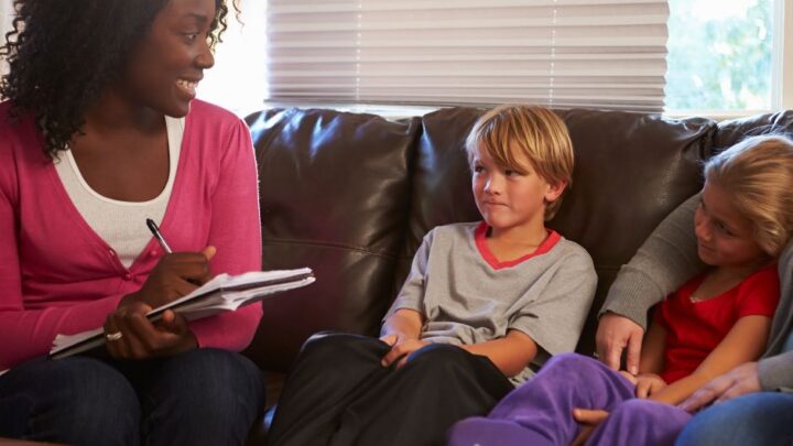 A photo of a social worker talking to two young children