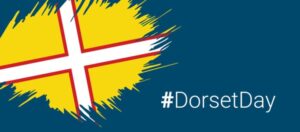 Yellow flag with a white and red cross, with the text hashtag Dorset Day.