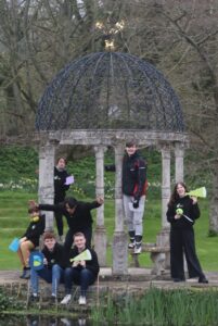 Young people in a group outside by a decorative structure