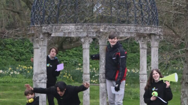 Young people in a group outside by a decorative structure