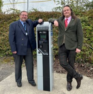 two men stood by a parking ticket machine