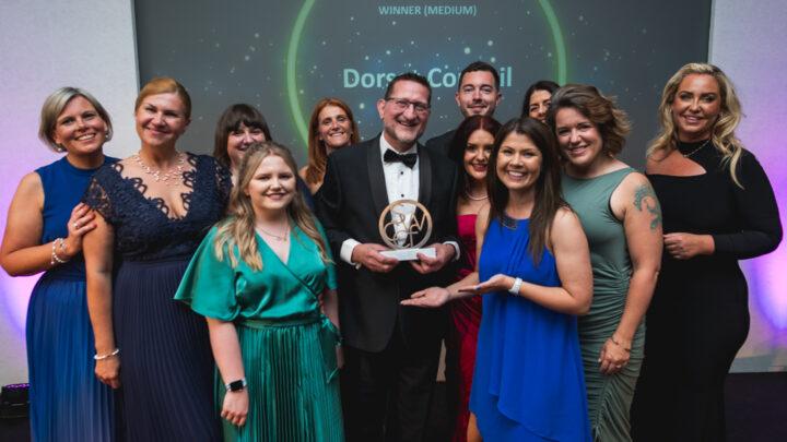 Dorset Council Customer Service officers accepting award with ceremony hosts