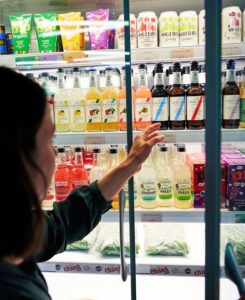individual opening door of fridge and reaching in