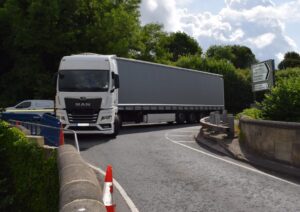 a big heavy goods vehicle lorry approaching a narrow bridge