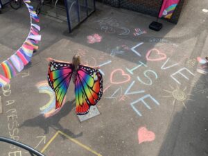 Girl with rainbow wings in a playground