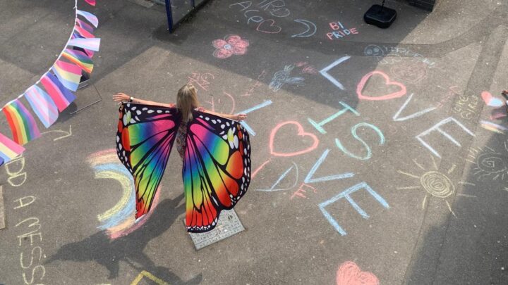 Girl with rainbow wings in a playground
