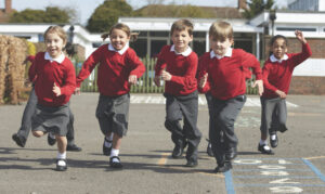 kids running through school yard towards camera