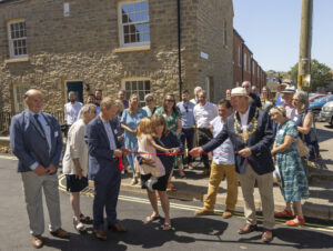 Resident Mandy Knott and grand-daughter cutting the ribbon at the Old Coal Yard, Bridport