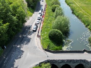 a river with a bridge over and a road to the left.