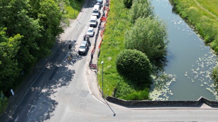 a river with a bridge over and a road to the left.