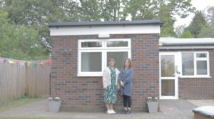 two people smiling in front of the bungalow