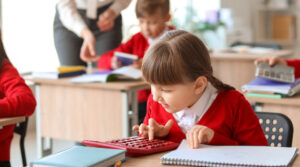 girl in red uniform using a calculator