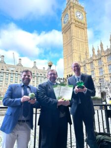 three people standing in front of Big Ben tower holding their award
